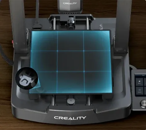 Mesa da melhor impressora 3D para iniciantes abaixo de R$ 2.000, a Creality Ender 3 V3 SE, com 220 mm de lado e uma peça recém-impressa sobre a placa de aço mola
