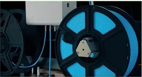 Rolos de filamento azul montados na traseira da impressora 3D Flashforge AD5X, com o mecanismo que puxa o fio de cada carretel